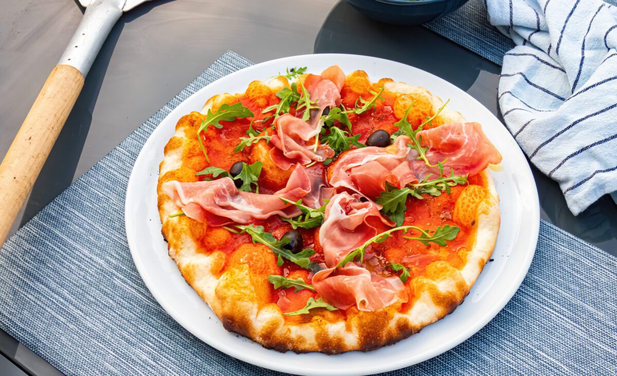 Barbecue pizza with prosciutto and arugula