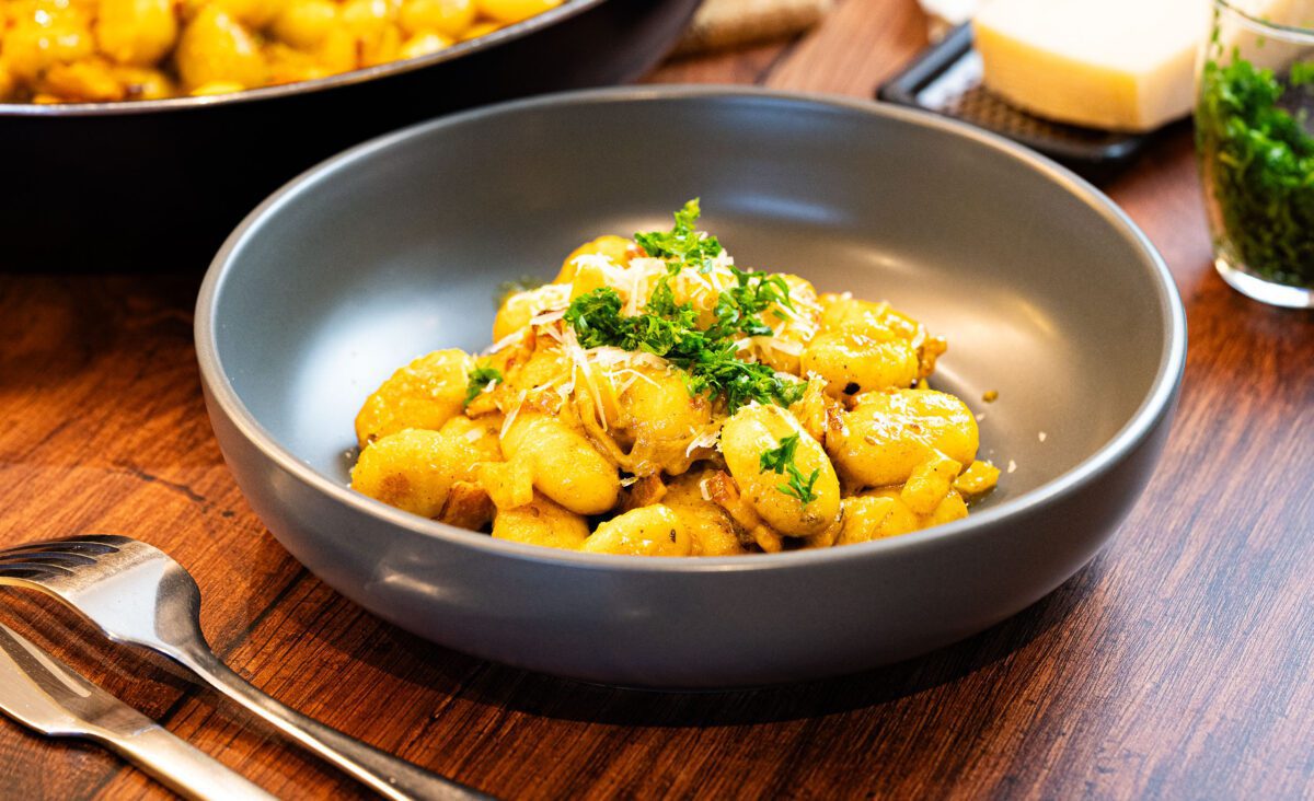 Pan-fried gnocchi with bacon, onion, yellow bell pepper, and spicy cream